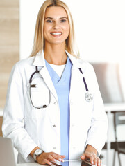 Woman-doctor controls medication history records and exam results while using tablet computer in sunny hospital. Medicine and healthcare concept