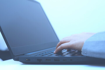 close-up of business woman hand typing and using laptop keyboard for searching with technology networking on working and job on desk at work place or work at home.