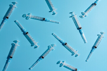 plastic syringe on a blue background with shadow.