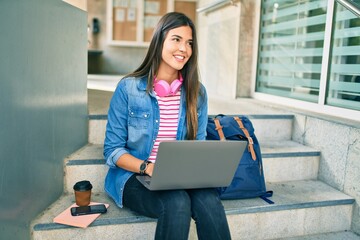 Young hispanic student girl smiling happy using laptop at the university.
