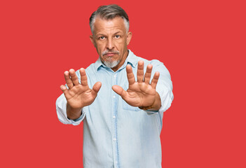 Middle age grey-haired man wearing casual clothes moving away hands palms showing refusal and...