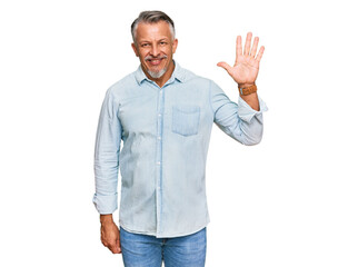 Middle age grey-haired man wearing casual clothes showing and pointing up with fingers number five while smiling confident and happy.