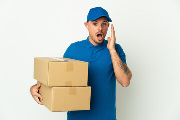 Delivery caucasian man isolated on white background with surprise and shocked facial expression