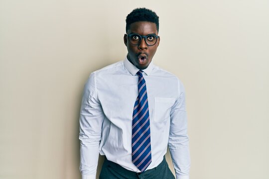 Handsome black man wearing glasses business shirt and tie afraid and shocked with surprise expression, fear and excited face.