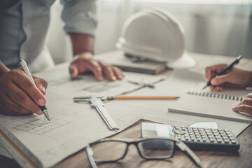 engineer working in office with blueprints, inspection in workplace for architectural plan,...