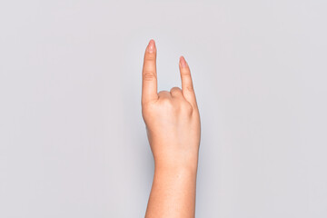 Hand of caucasian young woman gesturing rock and roll symbol, showing obscene horns gesture