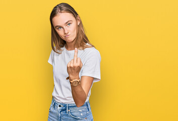 Beautiful young blonde woman wearing casual white t shirt showing middle finger, impolite and rude fuck off expression