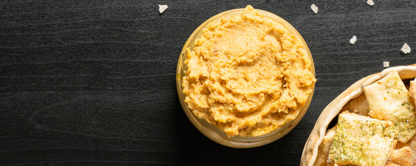 Homemade chickpea hummus and herbal healthy baked wheat vegan vegetarian cracker appetizer food savoury chip snack with black and white sesame and salt