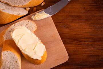 Bread and butter for homemade breakfast with coffee tea milk and organic slide whole wheat rye grain flour brown French  baguette with bio marmalade jam mix with orange passion fruit apricot