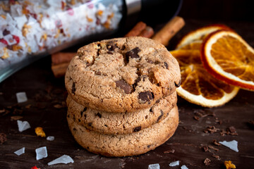Organic food snack tasty sweet dessert milk dark chocolate chip salt cookie closeup piece fruit orange raspberry hazelnut nuts cinnamon on cocoa cacao powder wooden table for new year Christmas gift