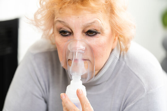 Senior woman making inhalation, elderly woman and nebulizer