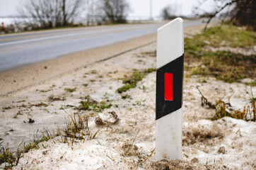 White road poles on the road for cars. Roadside post on a country road in Russia