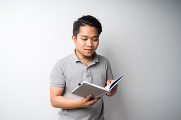 Portrait of Asian man holding book with face expression