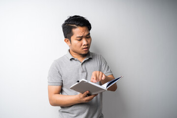 Portrait of Asian man holding book with face expression