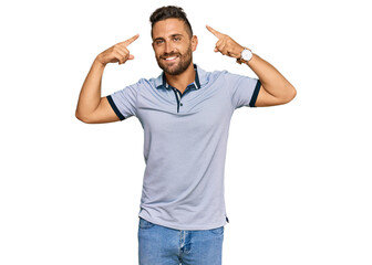 Fototapeta premium Handsome man with beard wearing casual clothes smiling pointing to head with both hands finger, great idea or thought, good memory