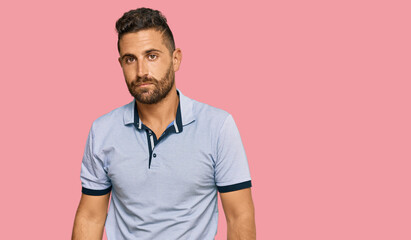 Fototapeta premium Handsome man with beard wearing casual clothes relaxed with serious expression on face. simple and natural looking at the camera.