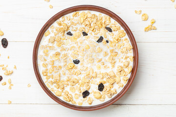 Cereal. Breakfast with muesli and raisins on a white wooden table. Top view