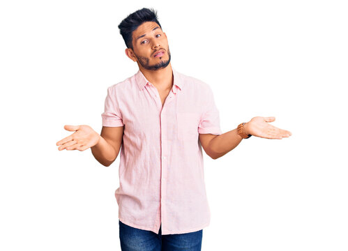 Handsome latin american young man wearing casual summer shirt clueless and confused with open arms, no idea concept.