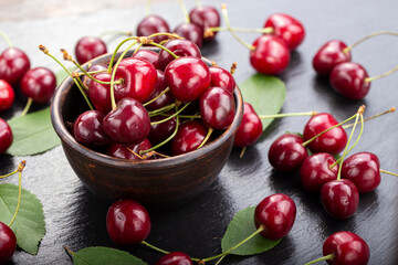 Freshly harvested cherries in a clay bowl from your home garden.