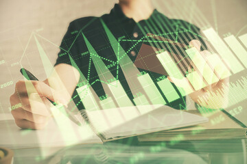 Double exposure of man hands holding a credit card and Forex graph drawing. Stock trading and digital fintech in Internet E-commerce concept.