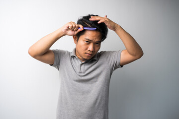 Fototapeta na wymiar young Asian man comb his hair isolated selective focus