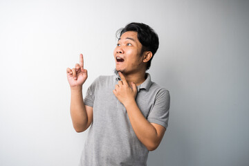 Portrait of Young Asian man, pointing with exciting, happy face expression, new fresh idea for advertisement. isolated selective focus.