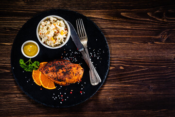 Stuffed chicken breast and coleslaw on wooden table
