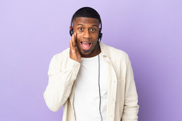 Telemarketer latin man working with a headset isolated on purple background with surprise and shocked facial expression