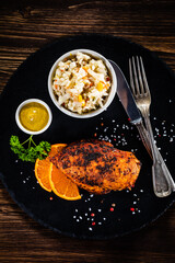 Stuffed chicken breast and coleslaw on wooden table
