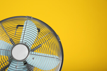 Modern electric fan on yellow background, closeup. Space for text