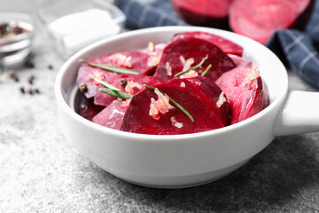 Raw beetroot slices, garlic and rosemary on grey table, closeup