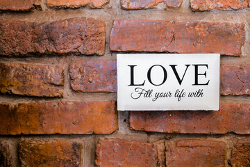 nameplate with love sign on the brick wall.