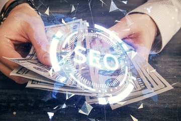 Multi exposure of seo drawing hologram and us dollars bills and man hands.