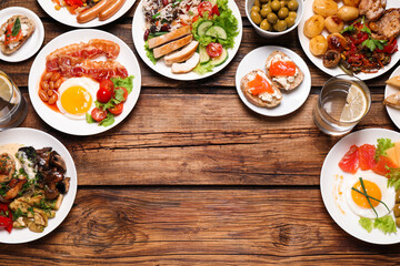 Buffet service. Flat lay composition with many  different dishes on wooden table, space for text