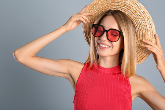 Beautiful woman in stylish sunglasses on grey background