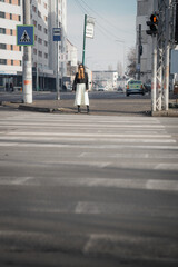 Pretty woman waiting for green sign near the pedestrian crossing