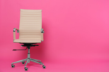 Comfortable office chair on pink background, space for text