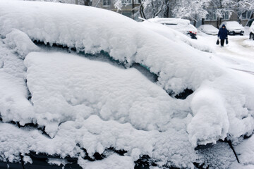 A snowstorm covered the city. Icy texture of a frozen car. Side view. Close-up