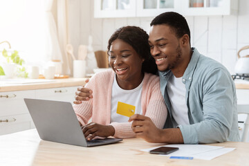 Online Payment. Black Spouses With Laptop And Credit Card In Kitchen