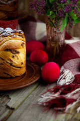 Easter cake kraffin. Kraffins with raisins, candied fruits and poppy seeds, sprinkled with powdered sugar. Close-up of homemade cake. Cruffin. Red colored eggs.