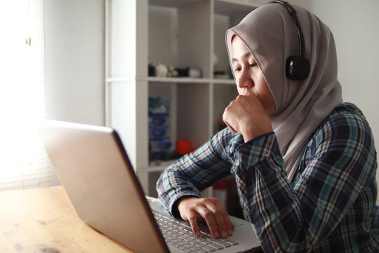 Asian Muslim Woman Having Video Teleconference On Her Laptop At Home, Online Learning Or Working From Home