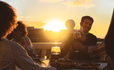 Young friends toasting with red wine at appetizer sunset time on patio house - Drink and food...
