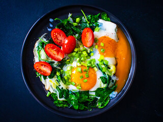 Sunny side up eggs with spinach on wooden table
