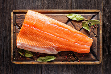 raw salmon fillet on a wooden board