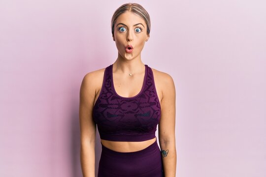 Beautiful blonde woman wearing sportswear over pink background afraid and shocked with surprise expression, fear and excited face.