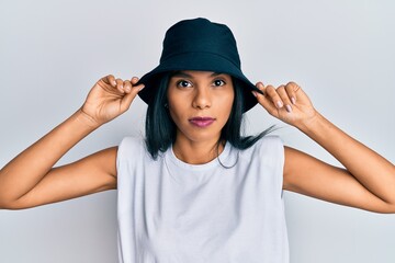 Young african american woman wearing fashion hat relaxed with serious expression on face. simple and natural looking at the camera.