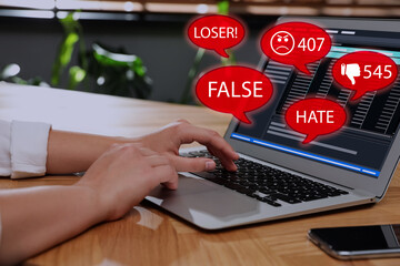 Woman using laptop and icons with offensive messages, closeup. Cyber bulling concept