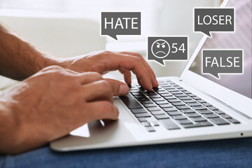 Man using laptop and icons with offensive messages, closeup. Cyber bulling concept
