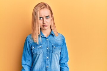 Beautiful caucasian woman wearing casual denim jacket skeptic and nervous, frowning upset because of problem. negative person.