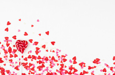 One heart-shaped lollipop for Valentine's Day on a white background with small hearts. The Concept of Love. top view. Minimalism is a colorful hipster style.